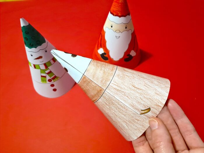 Put glue on the white tab on the side and close the cone to create the 3D character.